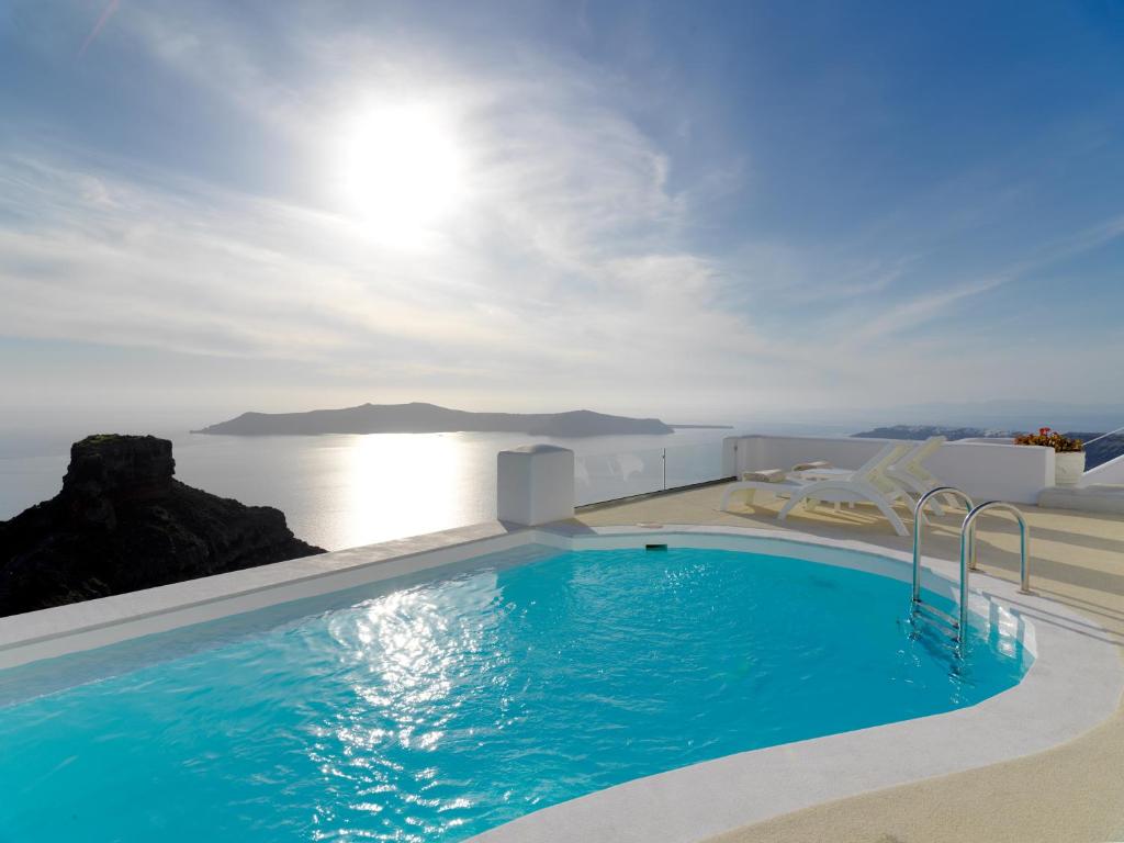 a swimming pool with a view of the ocean at Tholos Resort in Imerovigli