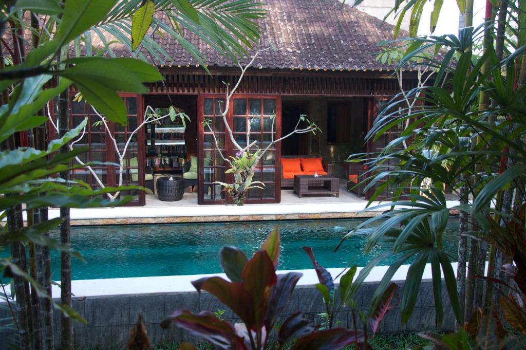 ein Haus mit einem Pool vor einem Haus in der Unterkunft Taman Rahasia Tropical Sanctuary and Spa in Ubud