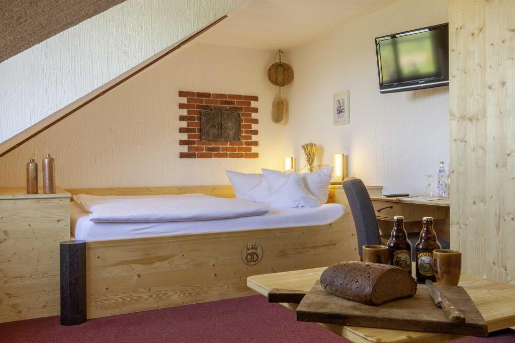 a bedroom with a bed and a table with a television at Burghotel Stolpen in Stolpen