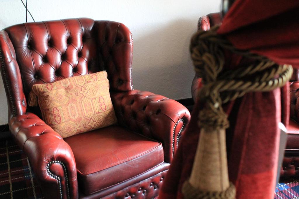 a brown leather chair with a pillow in a room at Old Court Hotel & Apartments in Symonds Yat