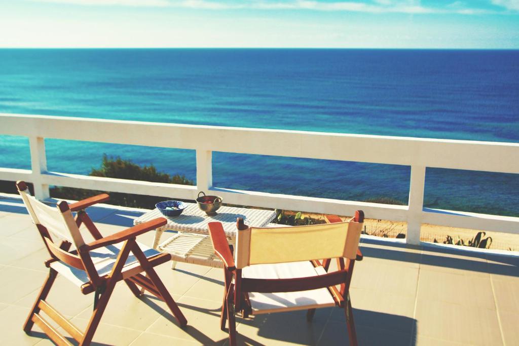 una mesa y sillas en un balcón con vistas al océano en Villa Moby Dick, en Mitikas