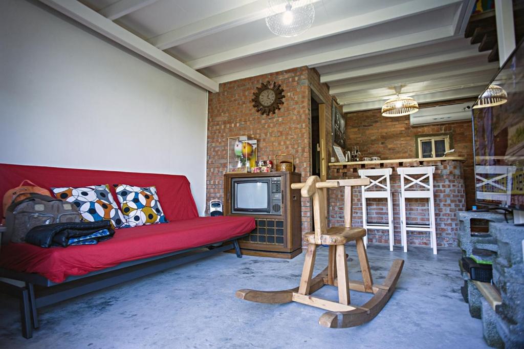 a living room with a red couch and a tv at Shabby Home 28 in Jiufen