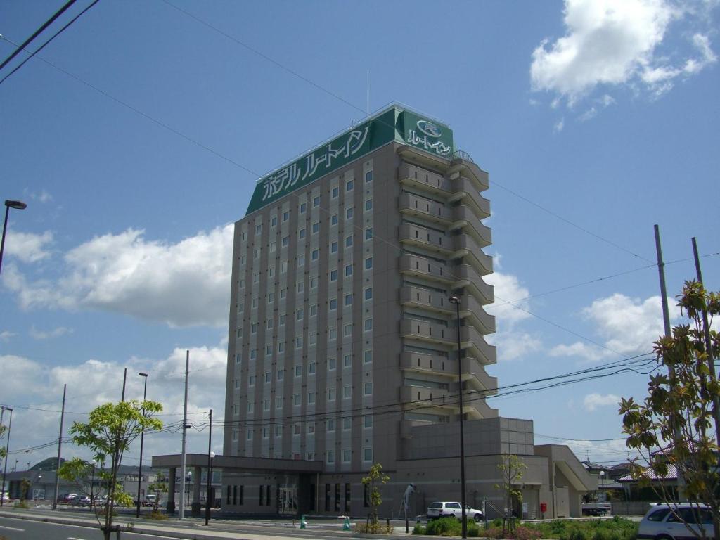 un edificio alto con un cartel en la parte superior en Hotel Route-Inn Ishinomaki Kanan Inter, en Ishinomaki