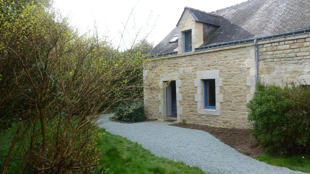 a stone house with a gravel path next to it at maison a locrio in Guern
