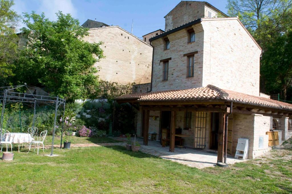 una casa con un edificio con un tavolo in un cortile di Casa della Strega a Montegiorgio