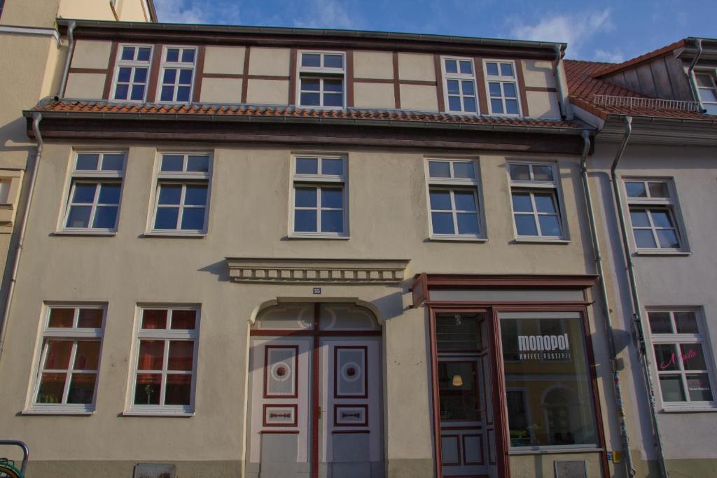 - un grand bâtiment avec une porte devant dans l'établissement Alte Posthalterei, à Stralsund