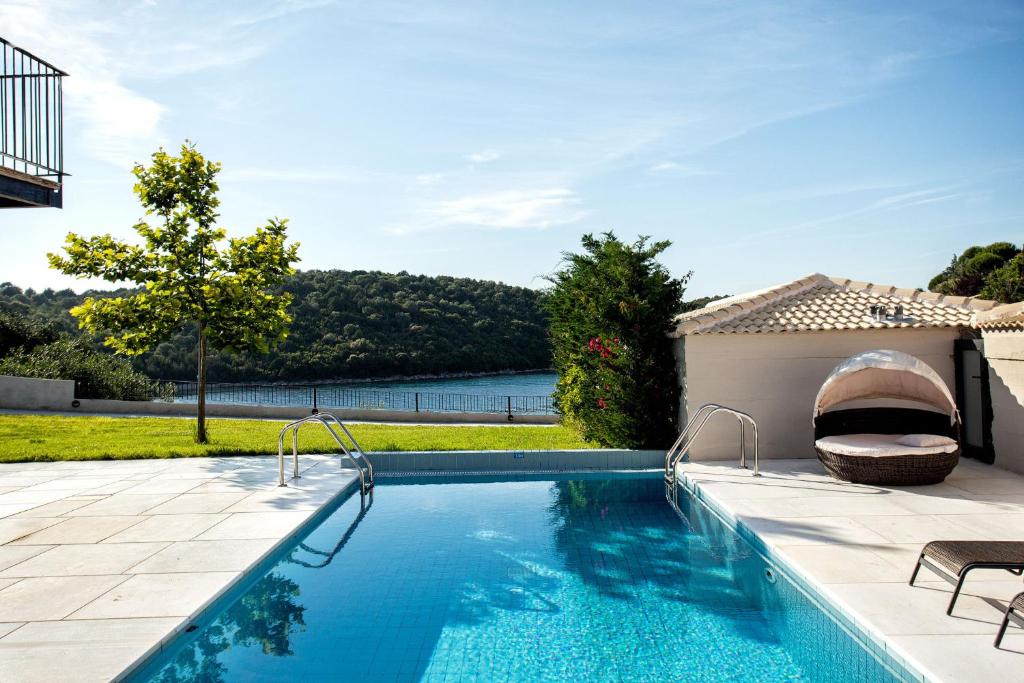 a swimming pool with a view of the water at Ornella Beach Resort & Villas in Syvota