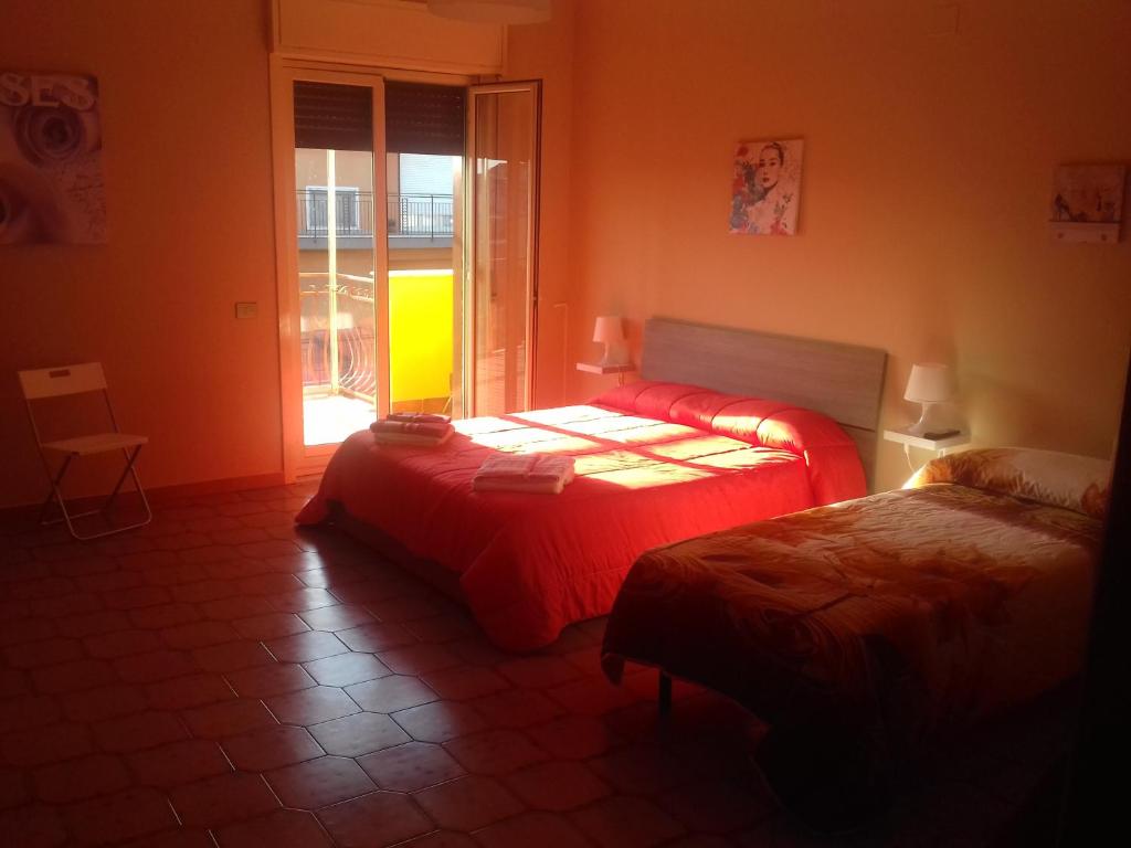 a bedroom with two beds in a room with a window at Bed and fly Aeroporto Catania reception h24 in Catania