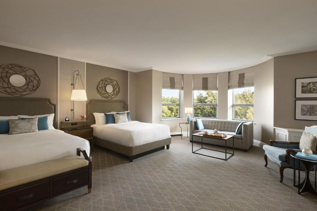 a hotel room with two beds and a couch at Fairmont Le Chateau Frontenac in Quebec City