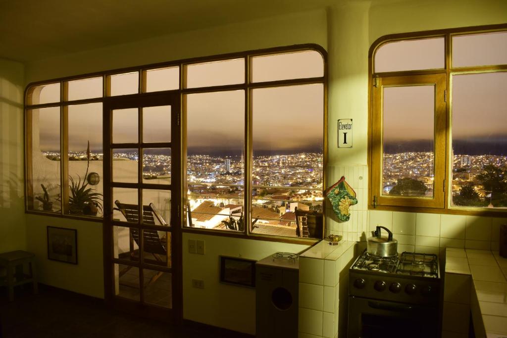 a kitchen with a view of a city seen through windows at Bella Vista El Tronco in Sucre