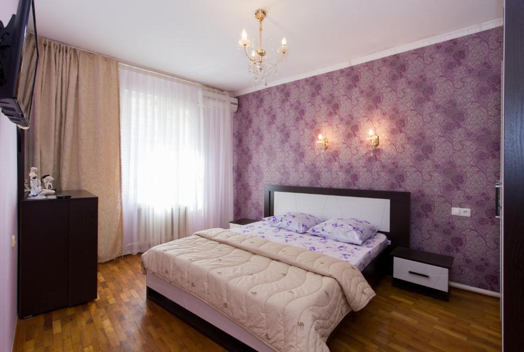 アドレルにあるAleks Apartmentの紫色の壁紙を用いた大型ベッド付きのベッドルーム1室