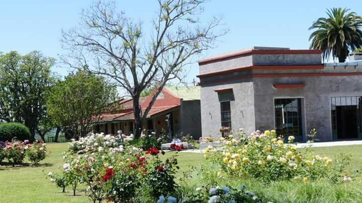 a building with a bunch of flowers in a yard at Estancia El Cangue in Porvenir