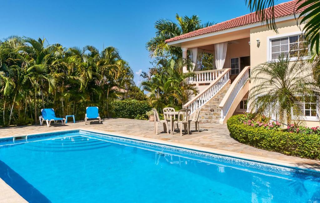a villa with a swimming pool and a house at Hispaniola Residencial in Sosúa