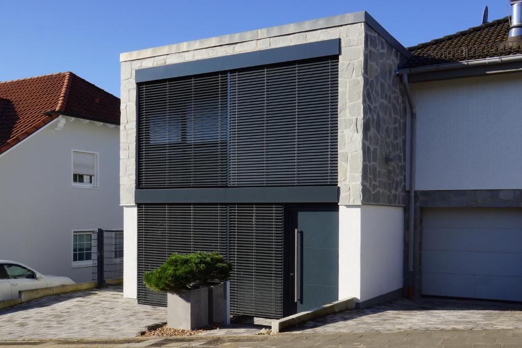 a house with a large garage with a black shutter at FeWo Dansenberg in Kaiserslautern