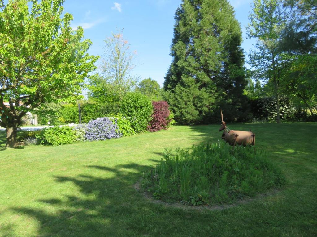una estatua de una vaca en un campo de hierba en Chez Pierre et Caroline, en Les Herbiers