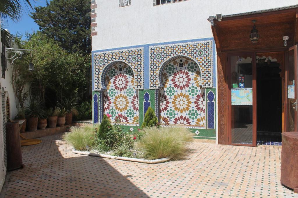 ein Gebäude mit einer gefliesten Fassade mit Pflanzen davor in der Unterkunft Malabata Guest House in Tangier