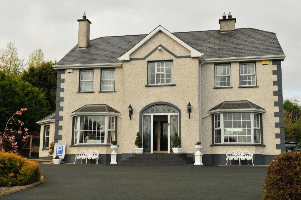 a house with white chairs in front of it at Killererin House B&B in Letterkenny