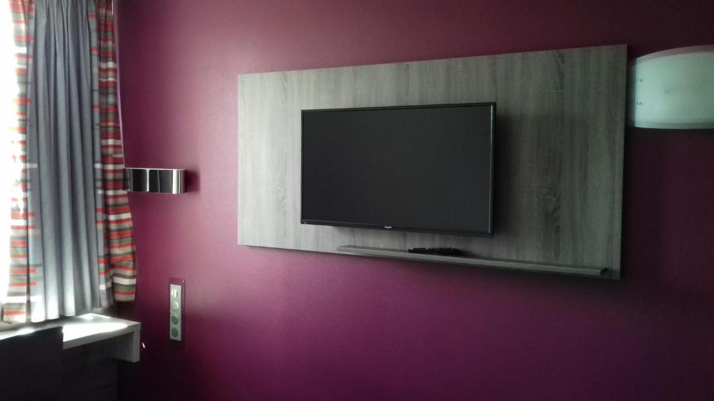 TV a/nebo společenská místnost v ubytování Hotel Arena Toulouse