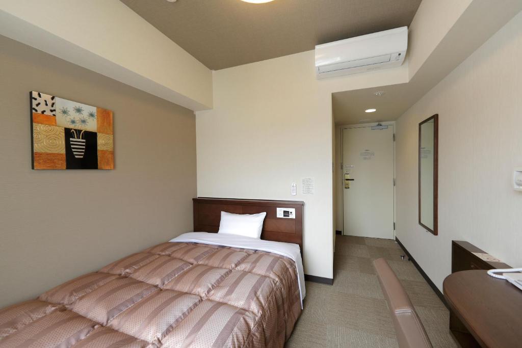 a bedroom with a bed and a sink in it at Hotel Route-Inn Sendaiizumi Inter in Sendai