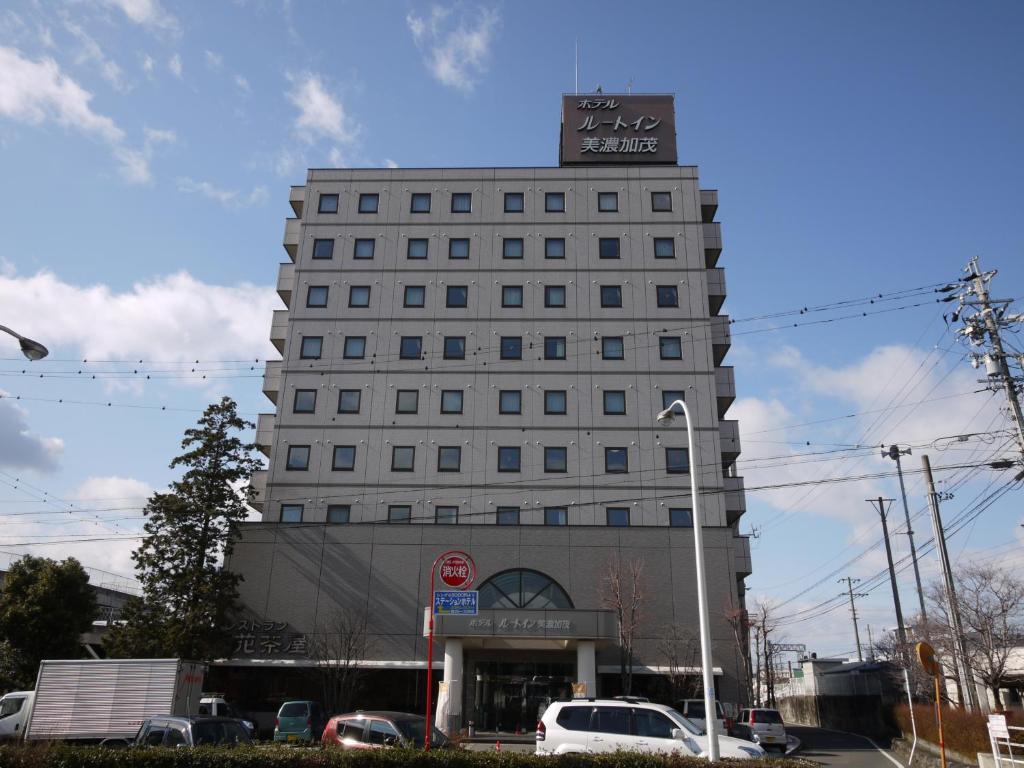 a tall white building with a sign on top of it at Hotel Route-Inn Minokamo in Minokamo