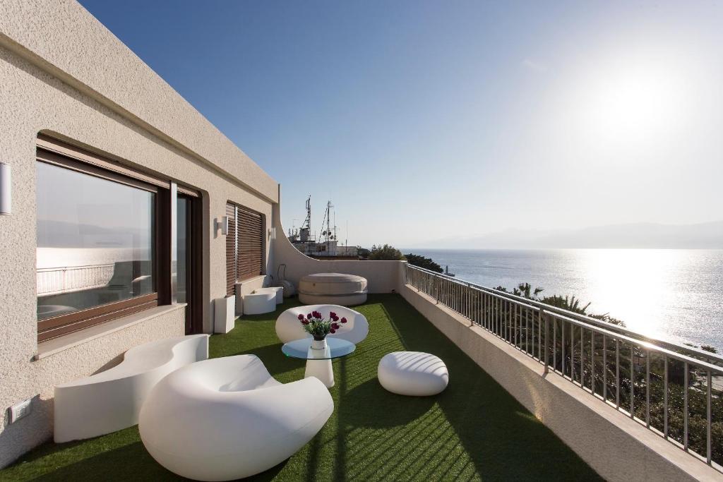 a balcony with white chairs and a view of the ocean at Reggio Suite in Reggio di Calabria