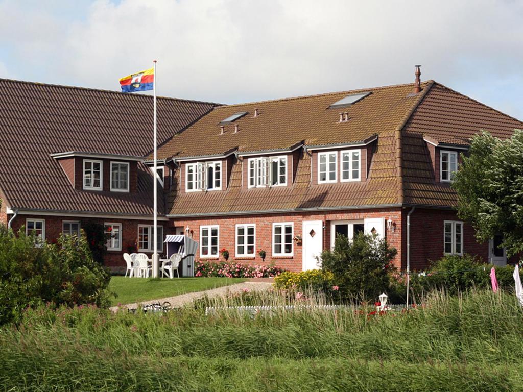 une maison arborant un drapeau devant elle dans l'établissement Friesenhof, à Pellworm
