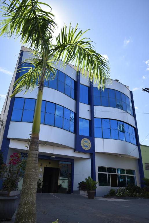 una palmera frente a un edificio en Hotel Sul Real en Ji-Paraná