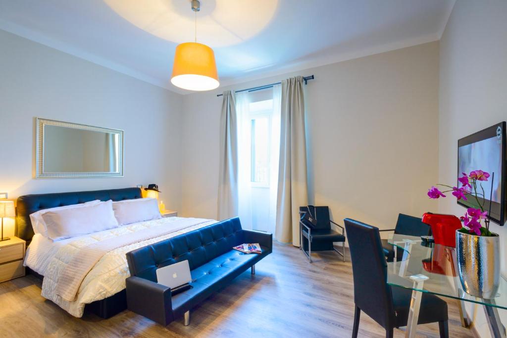 una camera con letto blu e tavolo e sedie di RHS Rienzo Suites a Roma