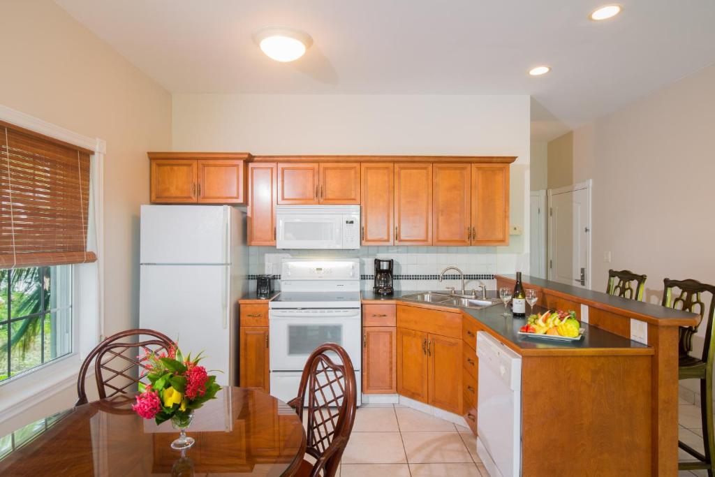 a kitchen with a white refrigerator and a table with chairs at Royal West Indies in Grace Bay