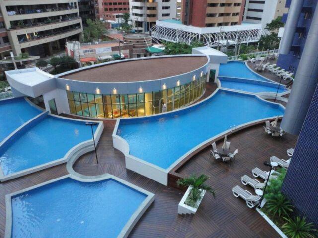 uma vista superior de duas grandes piscinas num edifício em Apartamento Vista Mar 4 Suítes em Fortaleza