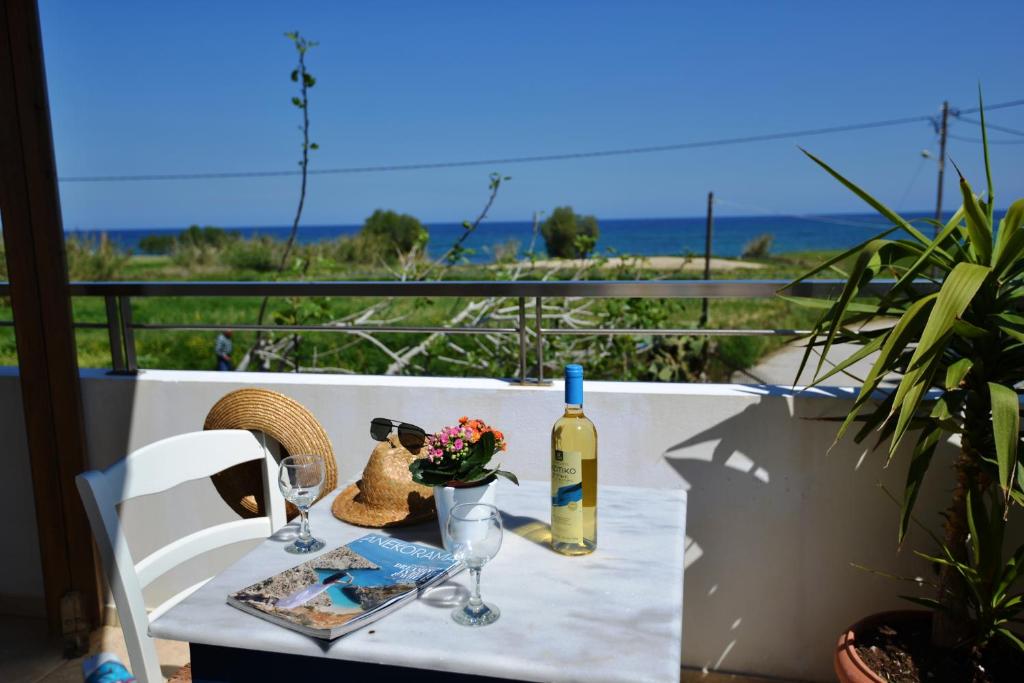 a table with a bottle of wine and a glass at Casa Nerium in Sfakaki