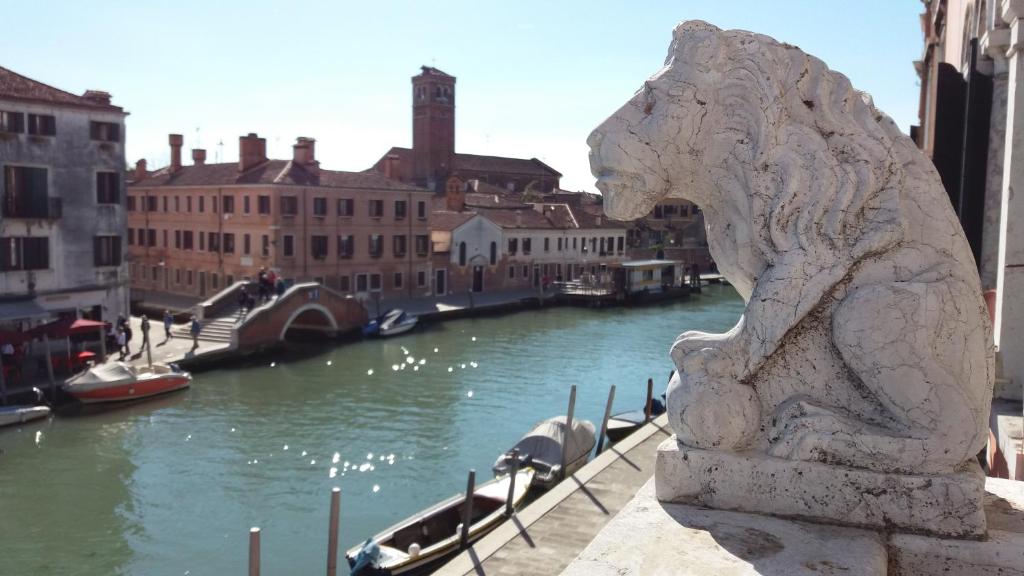 Hotel La Casa Veneziana, a statue of a lion next to a river with boats at La Casa Veneziana in Venice