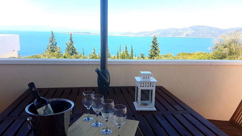 a table with wine glasses and a view of the ocean at Captain's Attic in Račišće