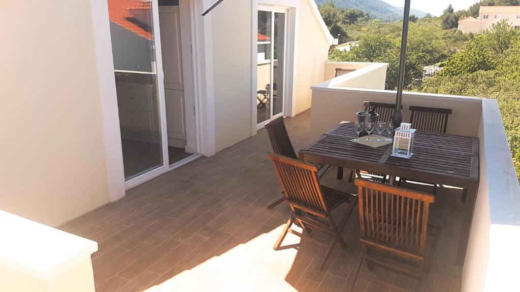 a balcony with a black table and chairs on a porch at Captain's Attic in Račišće