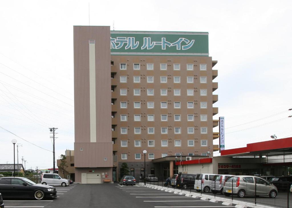 a building with a sign on the side of it at Hotel Route-Inn Yaizu Inter in Yaizu