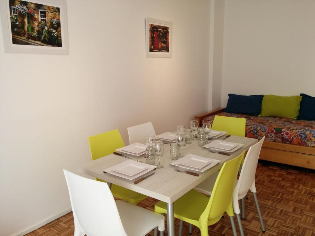 Apartamento Edificio Crucero في بوينس آيرس: غرفة طعام مع طاولة مع كراسي وأريكة