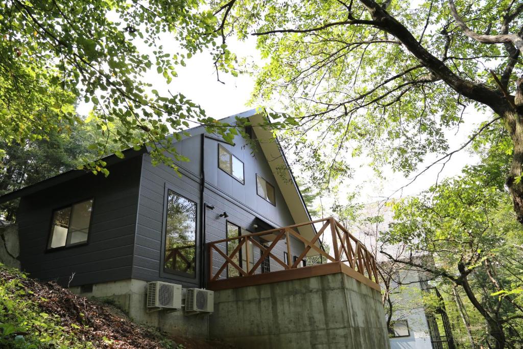 een zwart huis met een balkon bovenop een gebouw bij Tabinoteitaku Zao Miyagi in Zao