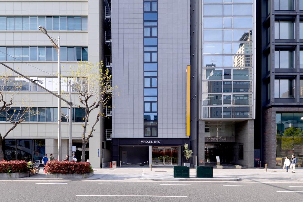 a tall building with people walking in front of it at Vessel Inn Shinsaibashi in Osaka