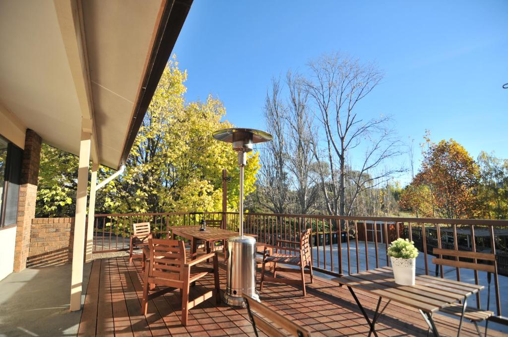 a patio with a table and chairs on a deck at Leski Club in Jindabyne