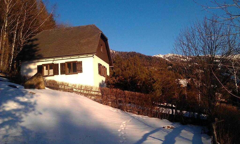 a house in the snow in front of a fence at Ferienhaus Ahornweg in Bad Kleinkirchheim