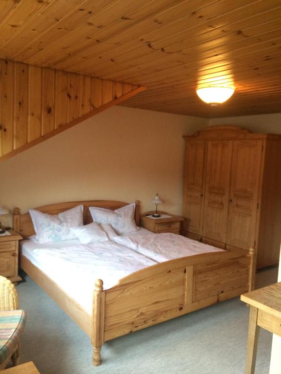 ein Schlafzimmer mit einem großen Bett in einer Holzdecke in der Unterkunft Haus am Wald in Bayerisch Eisenstein