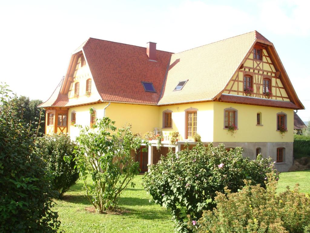 une maison jaune avec un toit brun dans l'établissement Maison d'hôtes Chez Christelle - Proximité Route des vins d'Alsace, à Griesheim-près-Molsheim