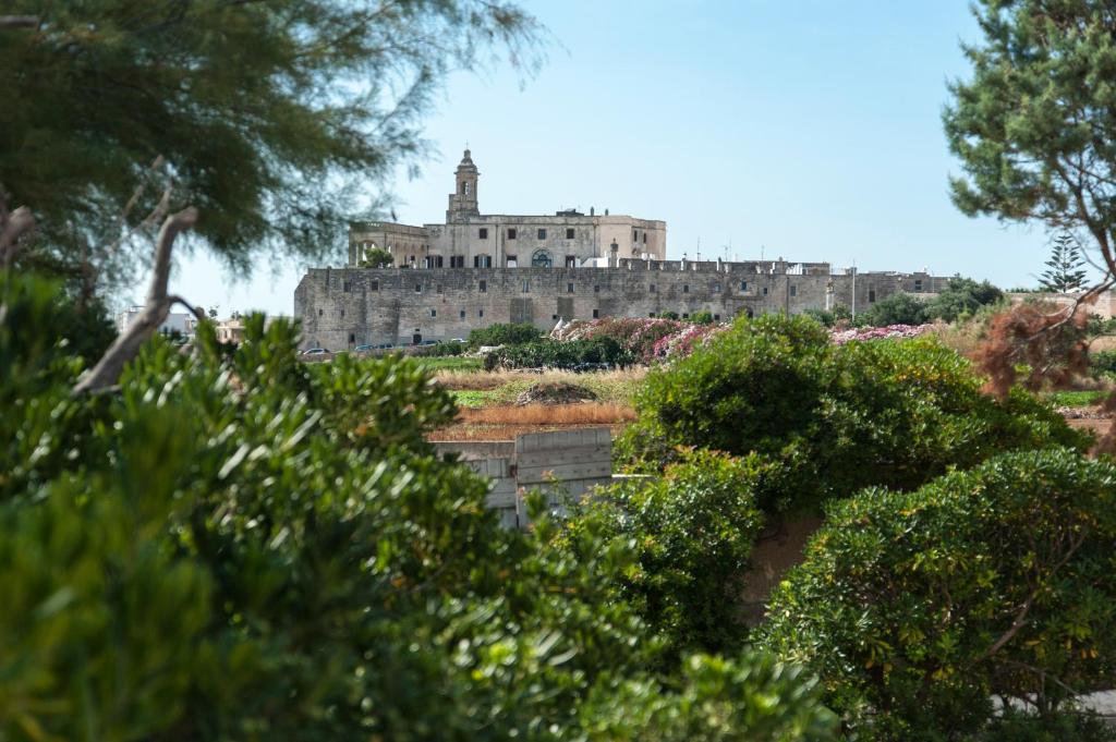 a castle on top of a hill with trees at Hotel San Giovanni in Polignano a Mare