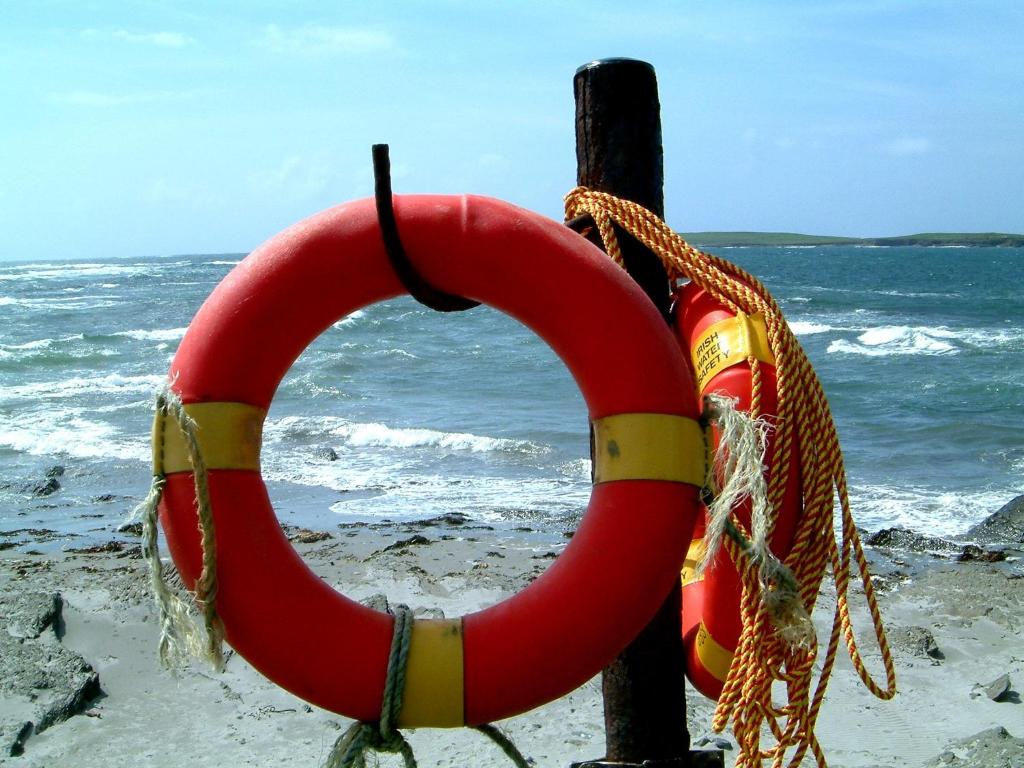 a red life buoy on a pole on the beach at Clonmore Lodge B&B in Quilty