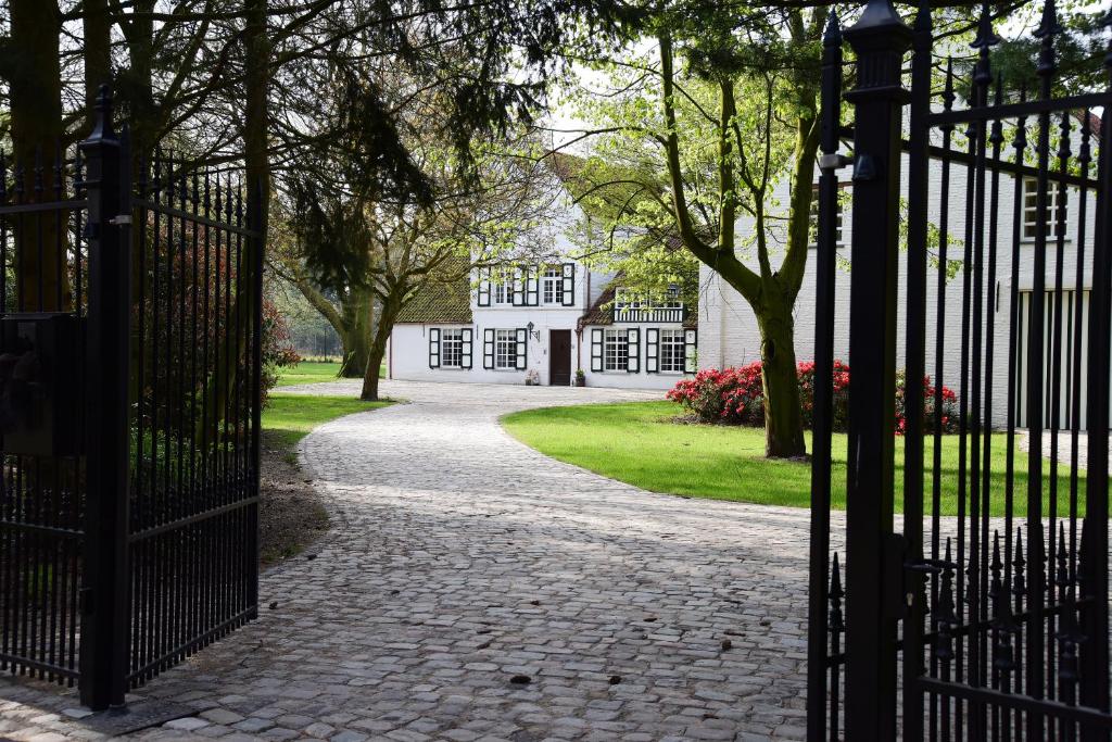 una entrada a una casa con una puerta y árboles en B&B Domein Rodin en Oud-Turnhout