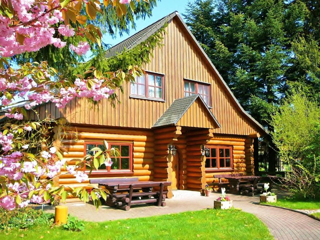 eine Blockhütte mit einem Picknicktisch davor in der Unterkunft Hotel Restaurant Baumhaus in Klein Pravtshagen