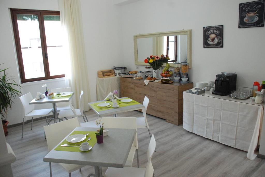 un soggiorno con tavoli e sedie e una cucina di La Fortezza a Crotone