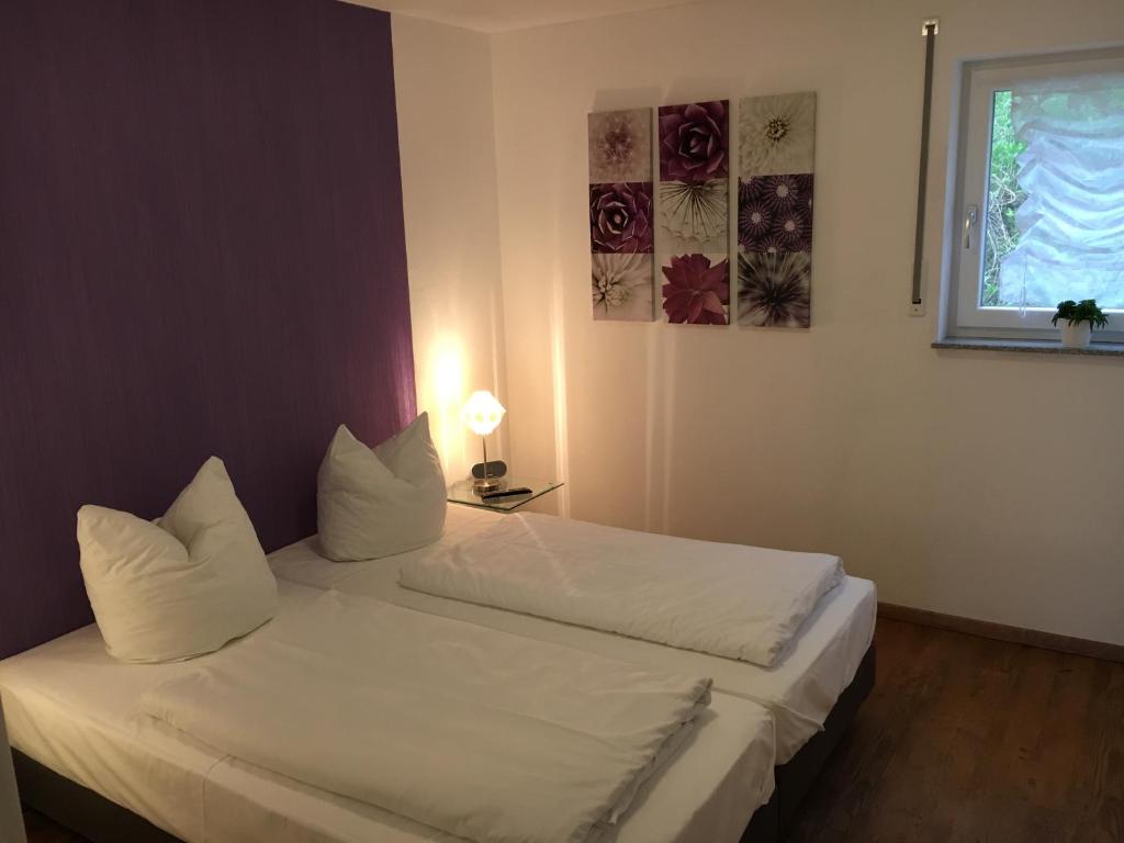 LitzendorfにあるApartments Talblickのベッドルーム1室(白いシーツが備わるベッド2台、窓付)
