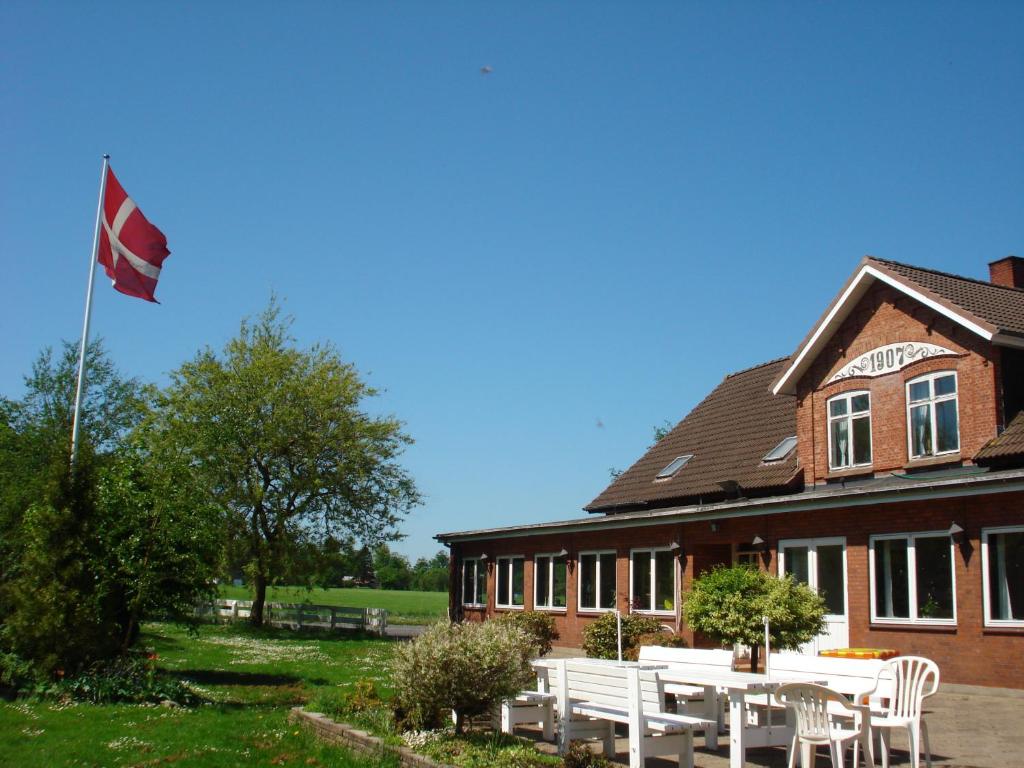 eine Flagge vor einem Gebäude in der Unterkunft Mikkelborg Kro in Rødding