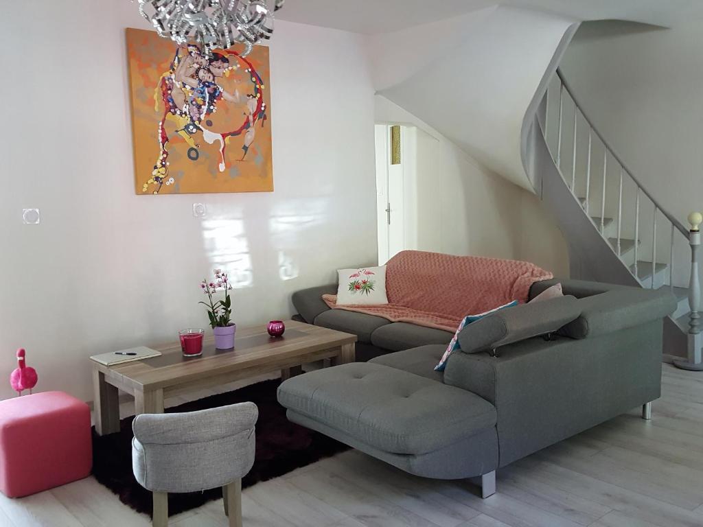 un salon avec un canapé et une chaise dans l'établissement Au Près du Zoo, à Saint-Aignan